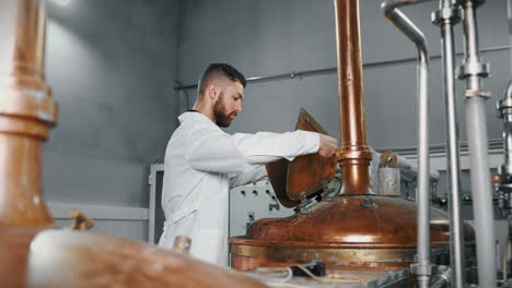 brewery worker operating copper fermentation tank