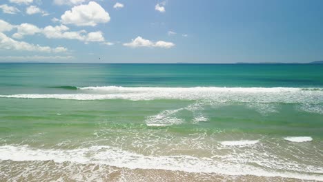 Olas-Rodando-Hacia-La-Playa-Mientras-Un-Dron-Sobrevuela