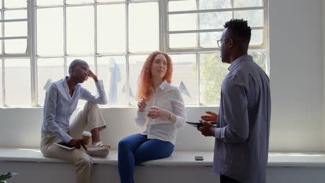 Front-view-of-young-mixed-race-business-team-eating-food-and-drinking-coffee-in-modern-office-4k