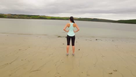 fit woman standing on the sand