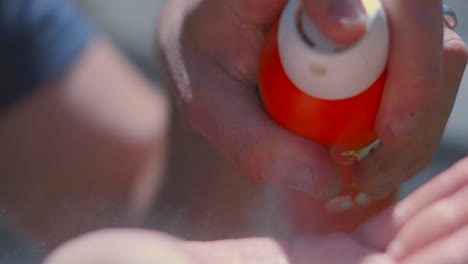 sunscreen being sprayed from aerosol can onto male hand ready to rub into skin to protect from potential sunburn from strong uv rays from sun during summer. dermatology prevention summer footage.