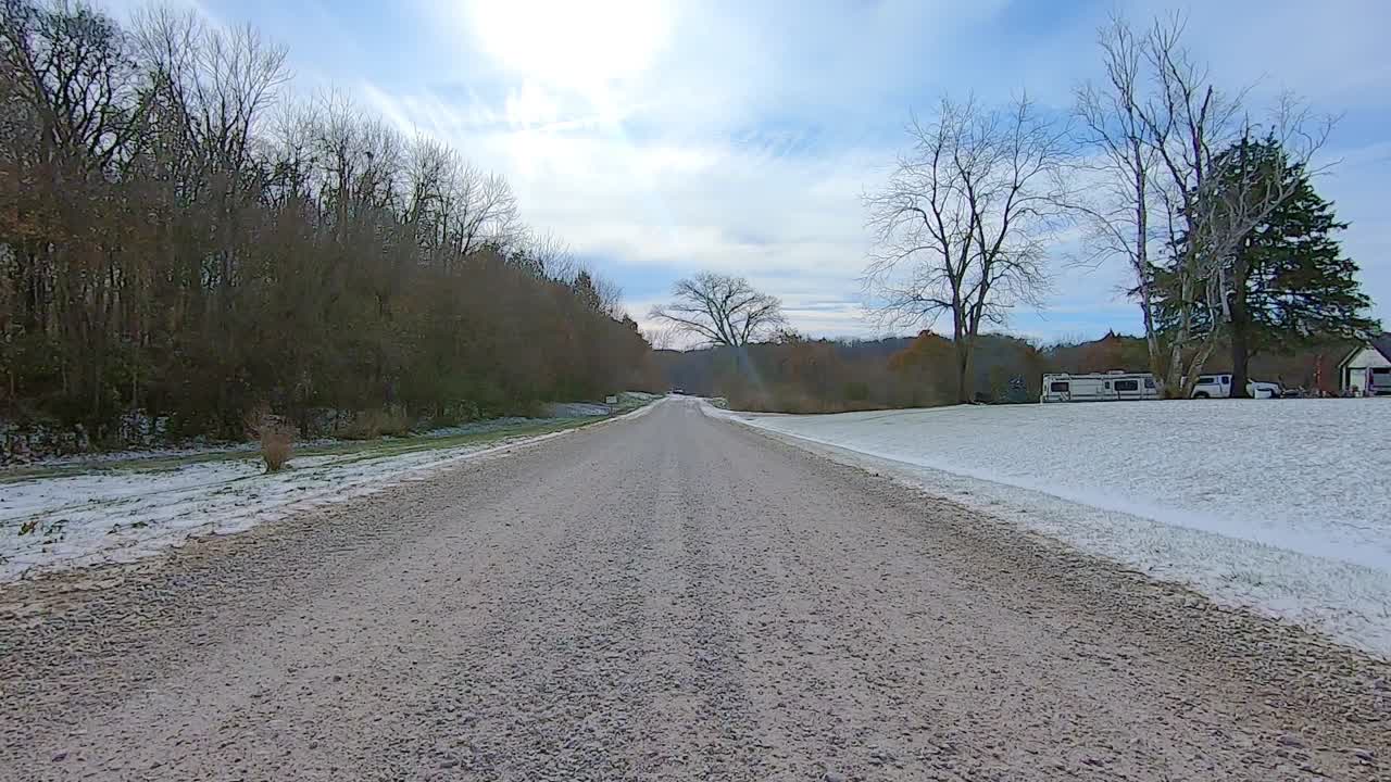 Point of View out of the drivers window; Driving past farms and fields in rural flat land Illinois USA.