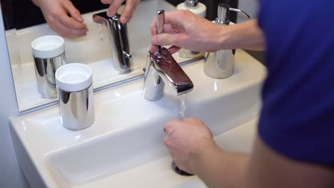 close-up of white person washing hands in clean and sterile bathroom