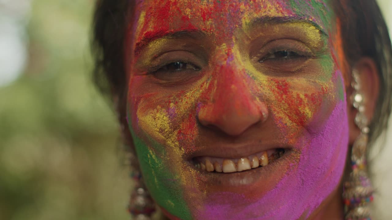 Primo piano di donne indiane con il viso imbrattato di vivaci colori Holi