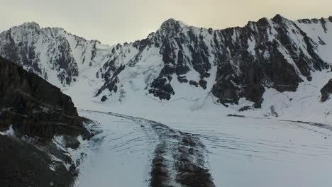 Tiro-De-Dron-Basculante-De-Una-Abertura-Cubierta-De-Nieve-En-El-Glaciar-Ak-sai-En-Kirguistán