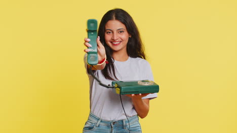 Indian-woman-talking-on-wired-landline-vintage-telephone,-advertising-proposition-of-conversation