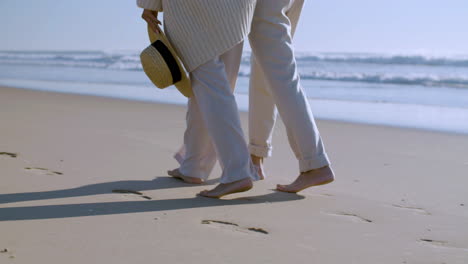 close up of an unrecognizable couple walking on the beach