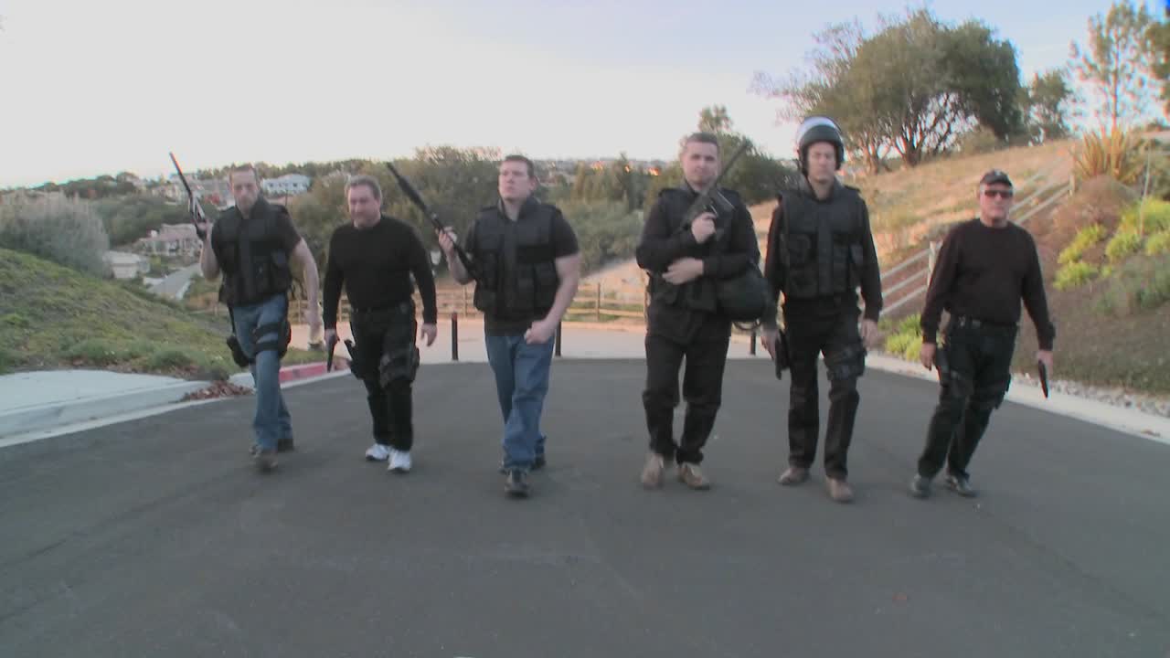 dea 요원으로 구성된 스와트 팀이 힘을 과시하며 마초적인 방식으로 거리를 걸어갑니다.