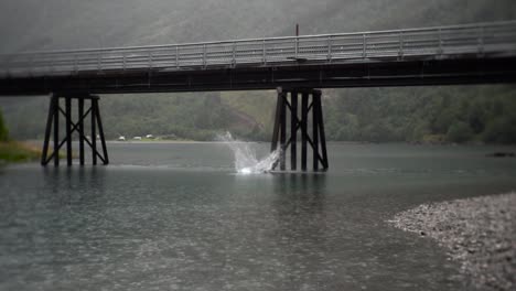 Man-performing-backflip-off-of-a-bridge-in-Norway,-Europe