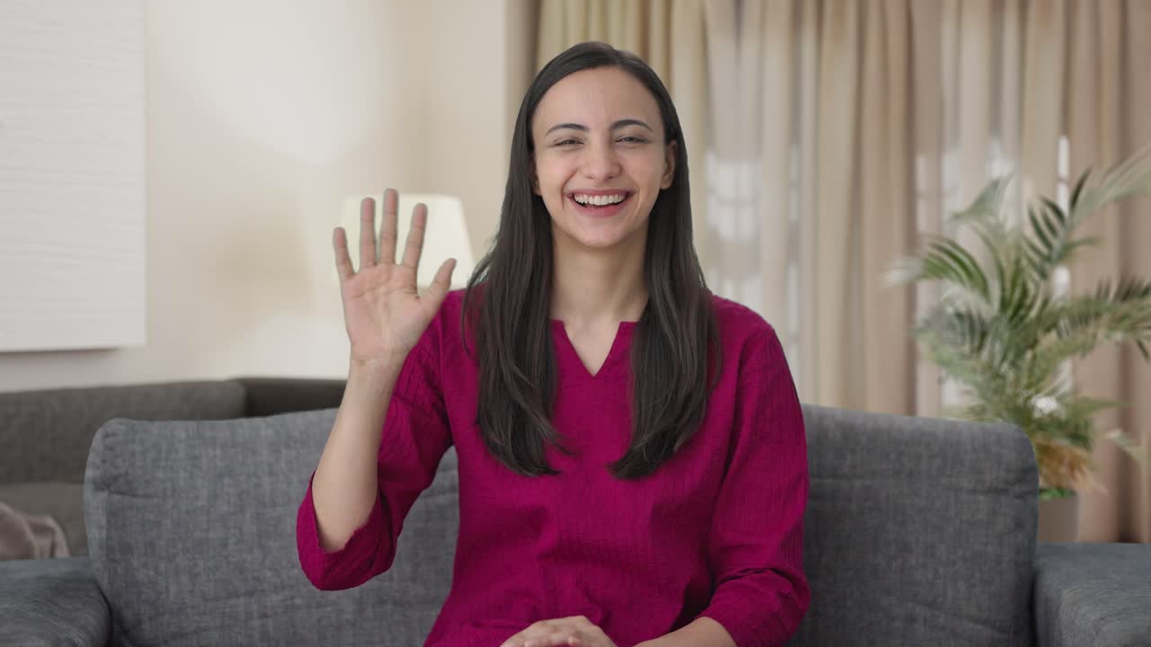 mujer india feliz saludando a la cámara