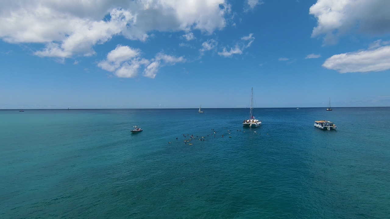 drone fpv aéreo acercándose a velero y buceadores en el océano pacífico frente a oahu, hawaii