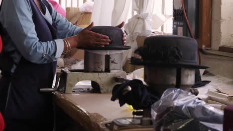 mujer de raza mixta trabajando en una fábrica de sombreros