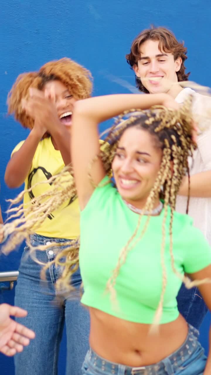 Latin friends dancing among multi-ethnic friends in an urban space