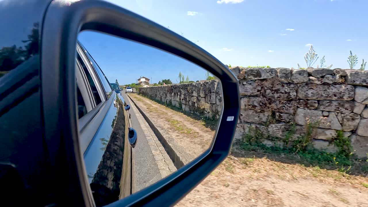 coche conduciendo a lo largo de una pared de piedra
