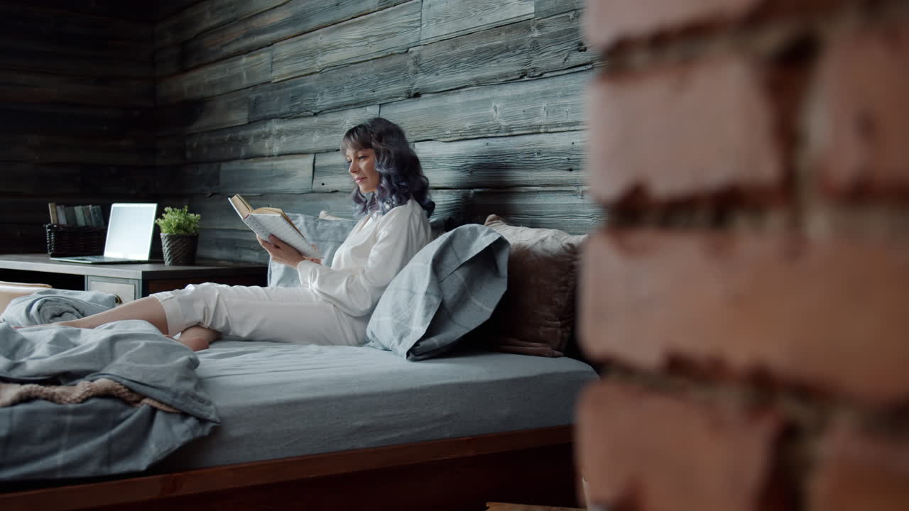 женщина читает в постели.