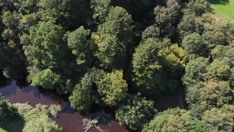 Imágenes-Aéreas-De-La-Presa-De-Control-De-Nivel-En-El-Río-Stockport,-Panorámica-Hacia-El-Bosque-Verde.