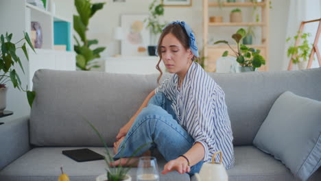 woman receives upsetting news during phone call on sofa