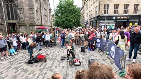 crowd gathers around street performer in edinburgh