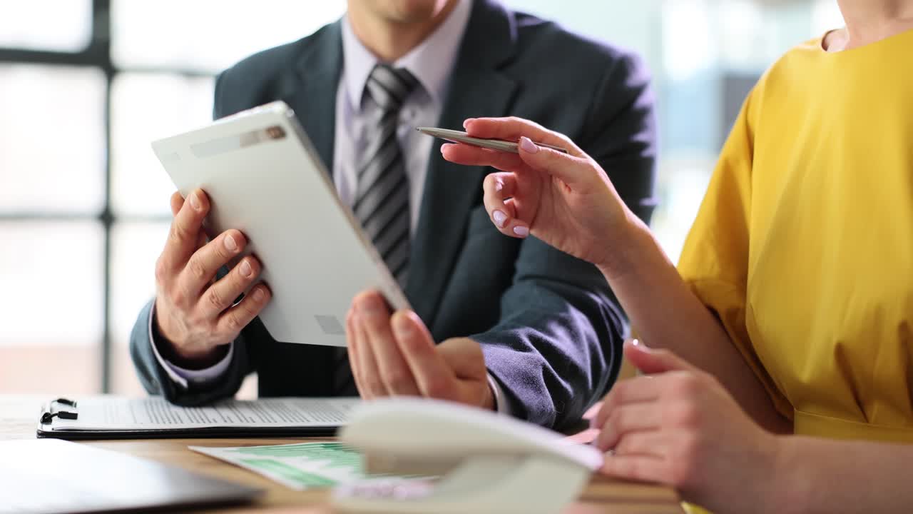 Two Professionals Collaborating with a Tablet in an Office Setting