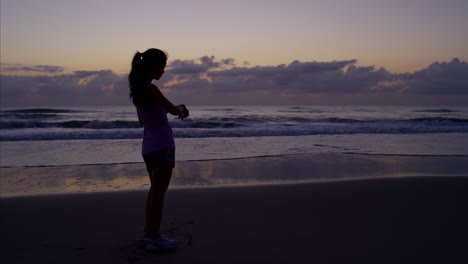 chica china asiática corriendo en la playa al amanecer