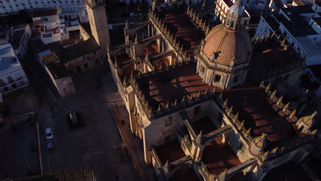 aerial birdseye over jerez cathedral, tilt up revealing city at golden hour, spain