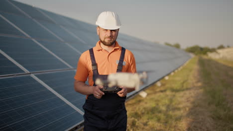 técnico inspeccionando paneles solares con un avión no tripulado