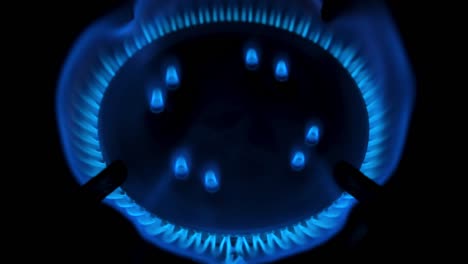 la estufa de gas se enciende aislada en fondo negro. concepto de déficit de gas natural. vista superior. video de resolución 4k