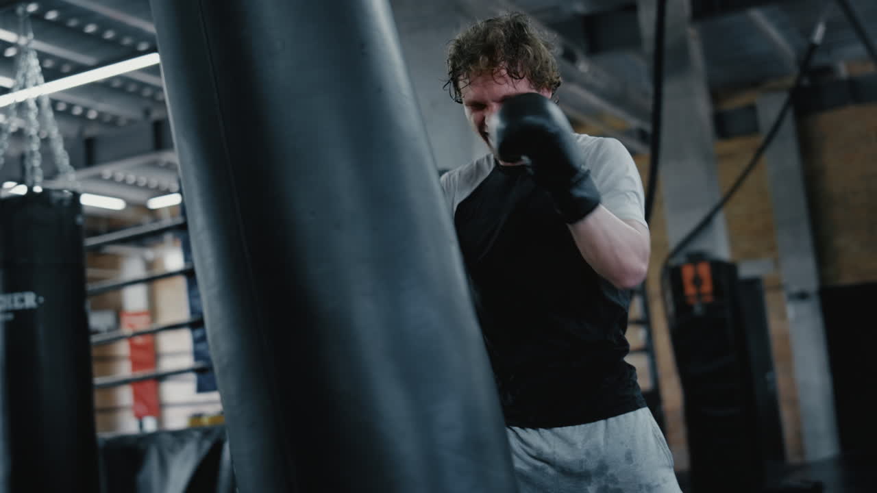 Ambitious fighter training in fitness center. Kickboxer warming up at gym
