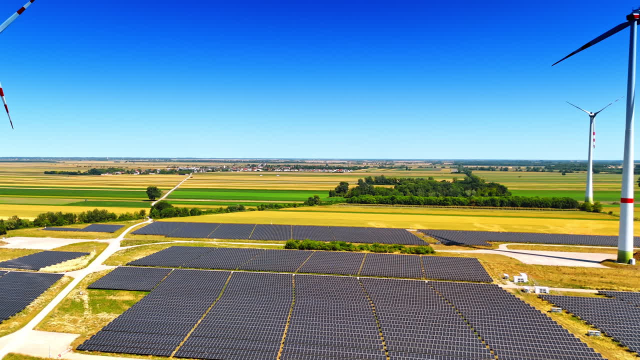 Rising over the yellow field where solar panels site is located. Few wind turbines are near the panels