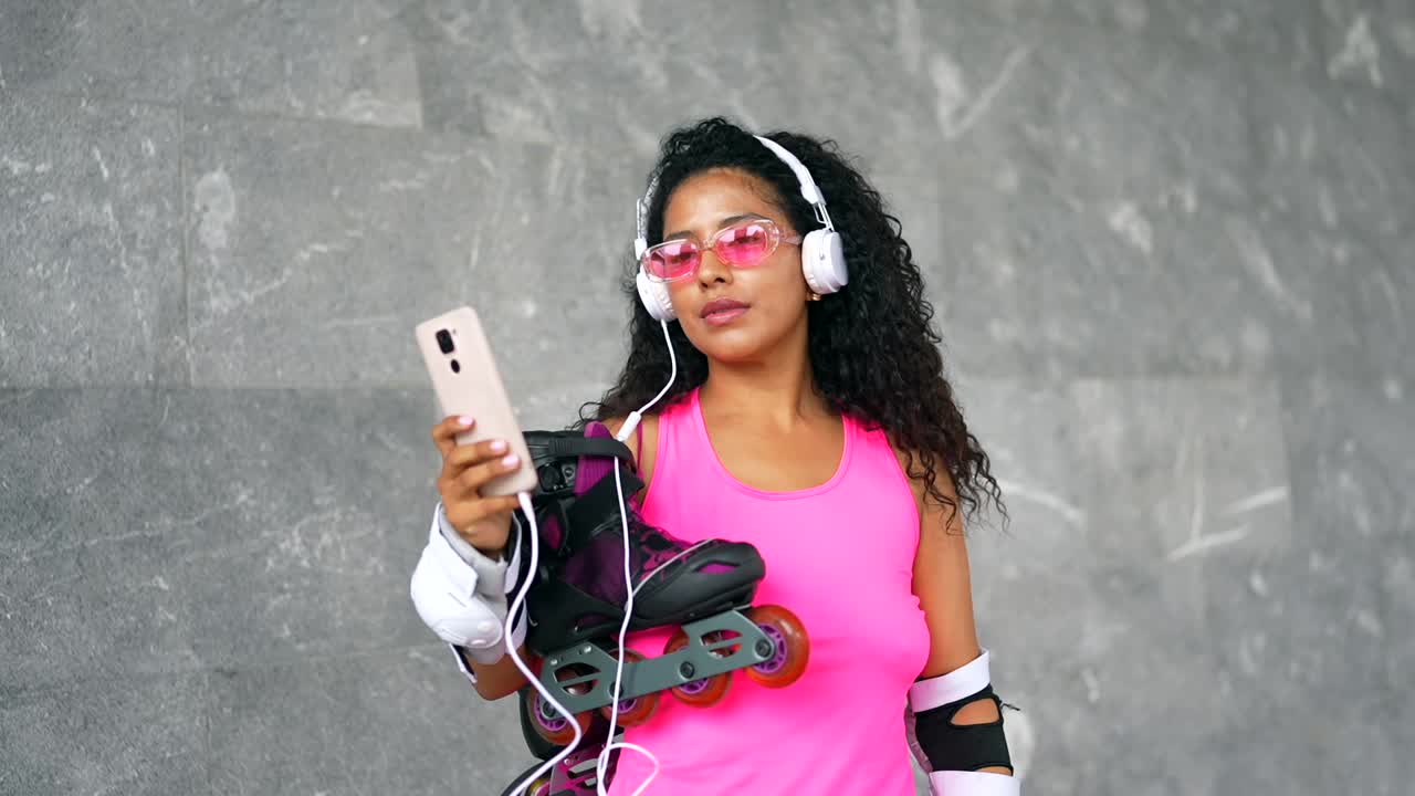 Woman rollerblading with headphones and mobile phone