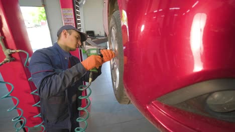 mecánico de automóviles reemplazando un neumático de automóvil en un taller de garaje. cámara lenta. servicio de automóviles