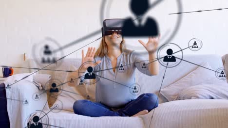 Animation-of-network-of-connections-with-icons-over-woman-wearing-vr-headset