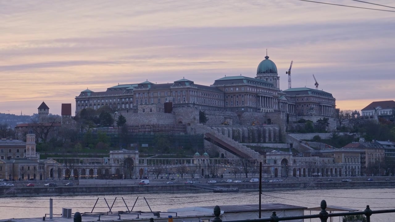 Vista panoramica del Castello di Buda che si erge sopra il Danubio a Budapest, in Ungheria, con architettura storica e la luce soffusa della sera sul paesaggio urbano lungo il fiume