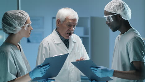 senior lab scientist talking with young multiethnic colleagues