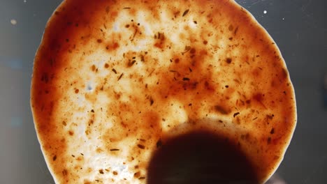 hand of talented chef finishing sprinkle mozzarella cheese on a glass surface that simulates pizza