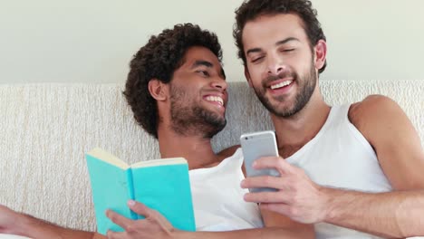 Homosexual-couple-speaking-together-on-bed