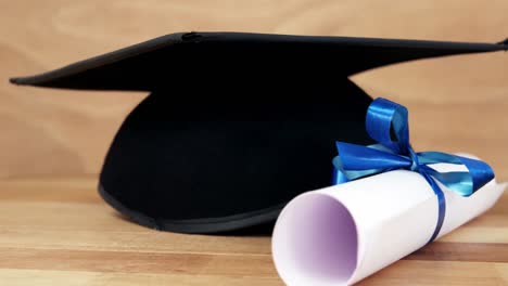 close-up of graduation certificate with mortar board on a table