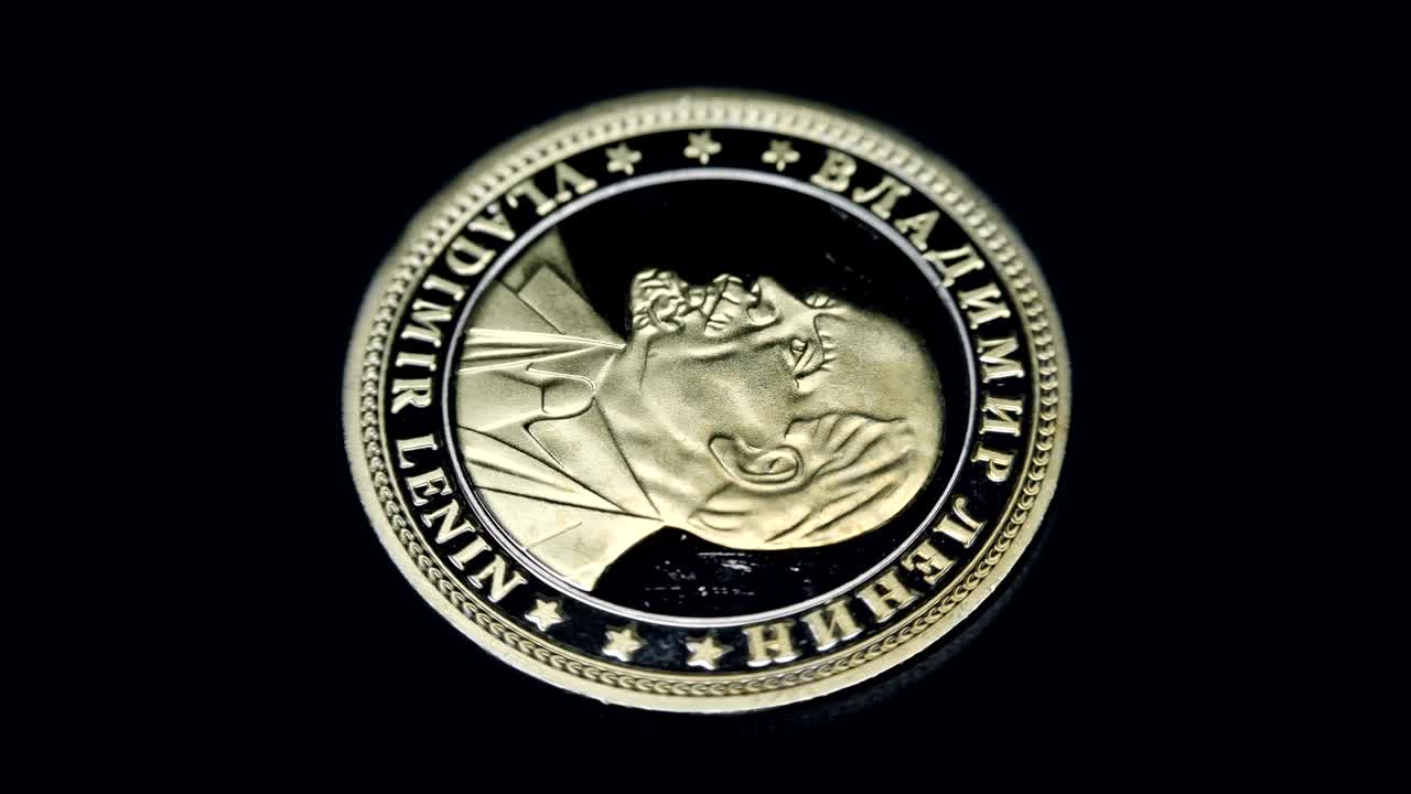 Russian souvenir coin Vladimir Lenin rotates on a black background. Macro. Closeup