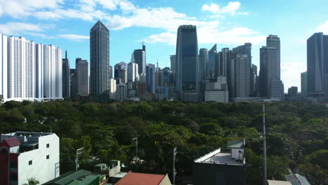 Drohnenschuss-über-Häusern-Und-Dem-Friedhof-In-Richtung-Der-Skyline-Von-Makati,-Philippinen