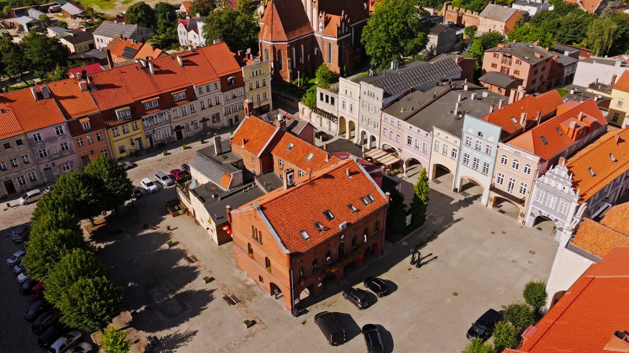 Cinematic orbiting drone view of Gniew old town square with red rooftops