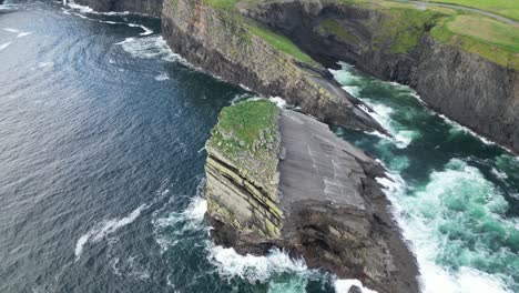 kilkee cliffs in ireland with waves crashing against rugged coastline, aerial view