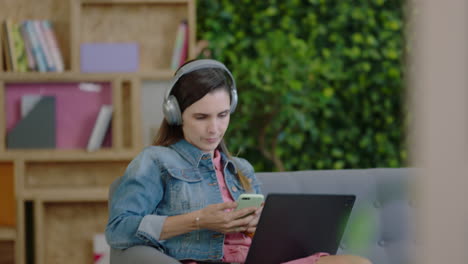 mujer de negocios joven usando smartphone en la oficina navegando mensajes disfrutando de correo electrónico comunicación de red trabajando en un proyecto de inicio disfrutando de escuchar música relajándose en el lugar de trabajo