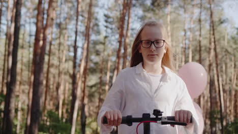 a child rides a scooter amongst tall trees 2