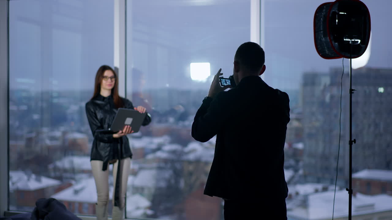 Photographer taking photo of a woman in a city studio