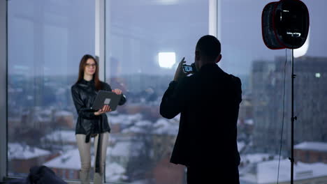 photographer taking photo of a woman in a city studio