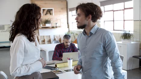 Focused-young-woman-shaking-hands-with-confident-colleague