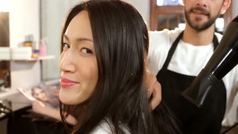 Smiling-woman-getting-his-hair-dried-with-hair-dryer