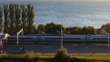 A modern train at a scenic coastal station