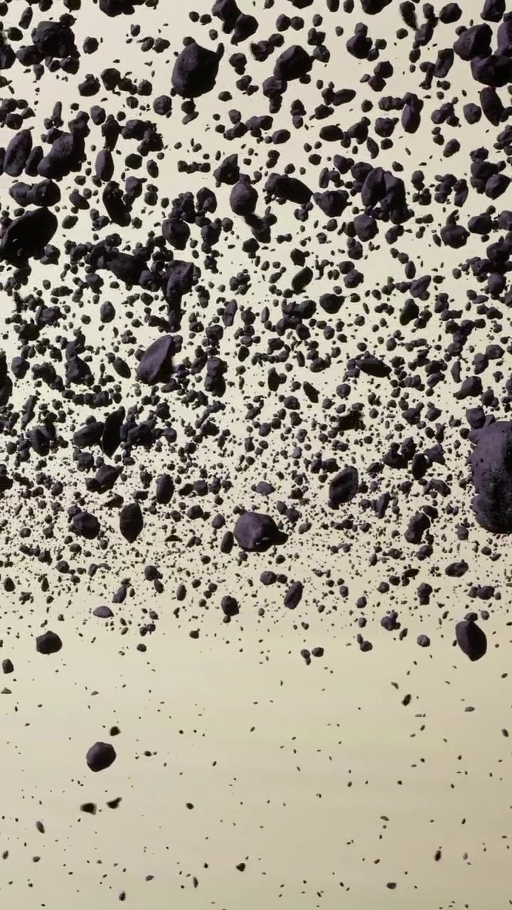 Rocce scure e detriti che galleggiano in un ambiente di luce astratto.