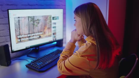 girl using computer at home. young woman watching video on computer in room